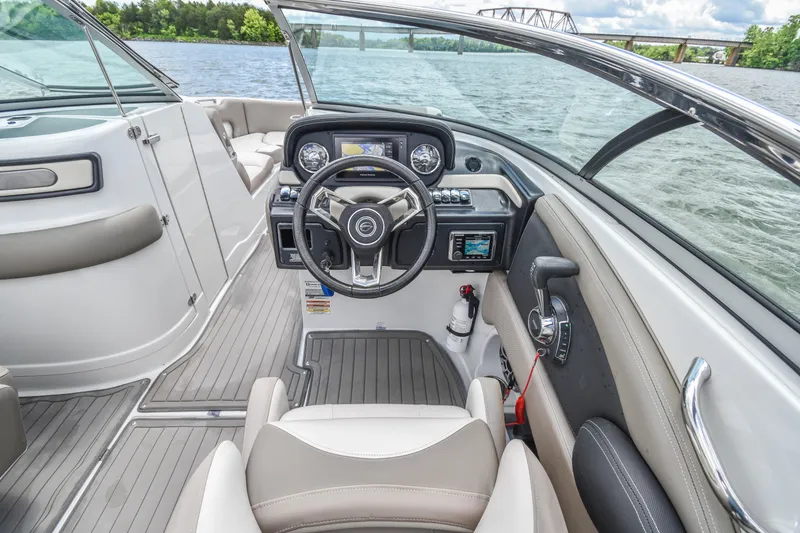 Slide: The Image of 2019 Crownline Eclipse E255 SURF boat interior with steering wheel and dashboard on a lake. - 19