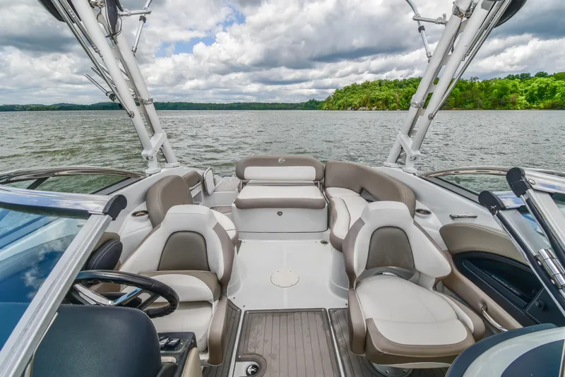 Slide: The Image of 2019 Crownline Eclipse E255 SURF boat interior with seating, on a scenic lake. - 23