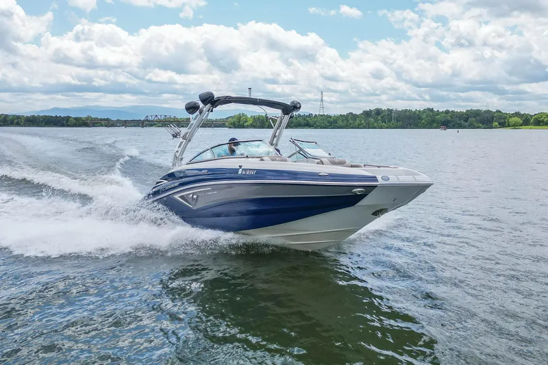 Slide: The Image of 2019 Crownline Eclipse E255 SURF boat cruising on a lake under a cloudy sky. - 5