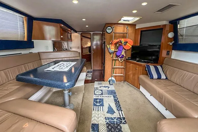 Slide: The Image of Interior of 2002 Carver 350 Mariner yacht with seating, table, and nautical decor. - 16