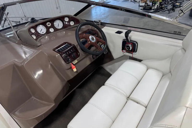 Slide: The Image of 2005 Regal Commodore 2665 boat interior with steering wheel, gauges, and white seating. - 11