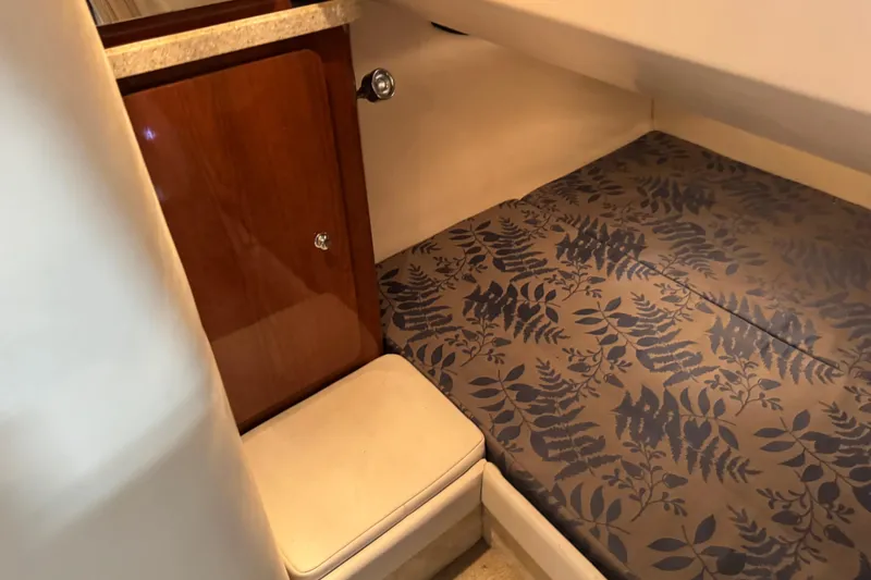 Slide: The Image of Interior cabin of 2005 Regal Commodore 2665 with patterned bedding and wooden cabinet. - 16