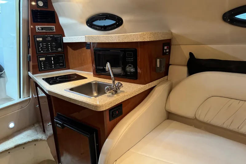 Slide: The Image of 2005 Regal Commodore 2665 boat interior with kitchenette, sink, and seating area. - 26