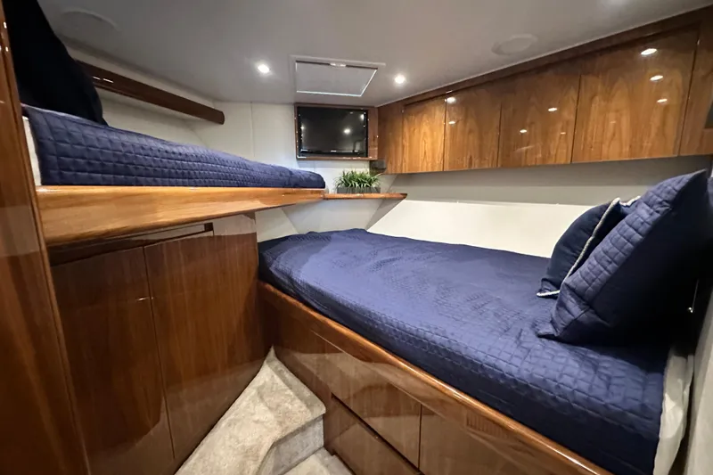 Slide: The Image of Luxurious cabin interior of 2017 Viking 55 Convertible yacht with wooden finishes and blue bedding. - 114