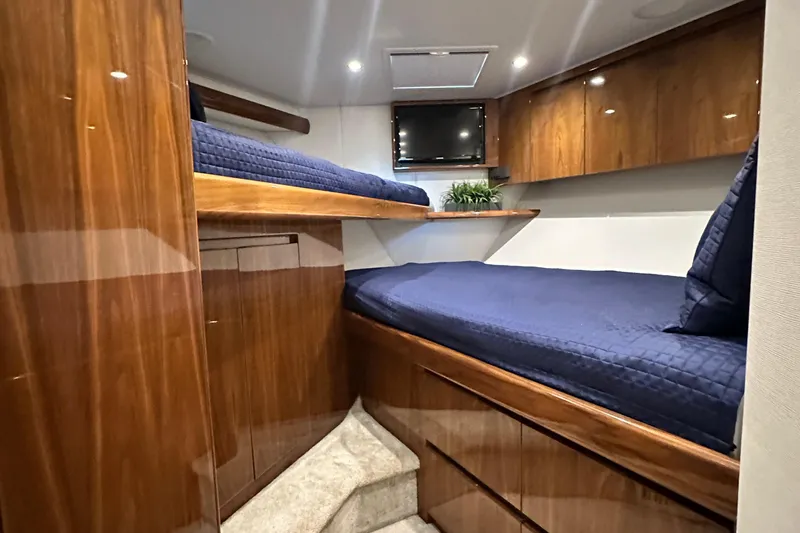 Slide: The Image of Luxurious cabin interior of 2017 Viking 55 Convertible yacht with wooden finish and blue bedding. - 115