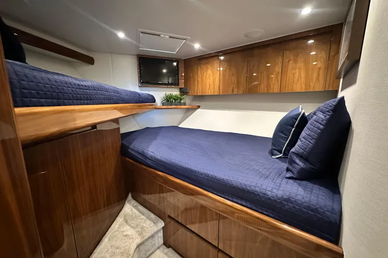Slide: The Image of Luxurious cabin interior of 2017 Viking 55 Convertible yacht with wooden finishes and blue bedding. - 116