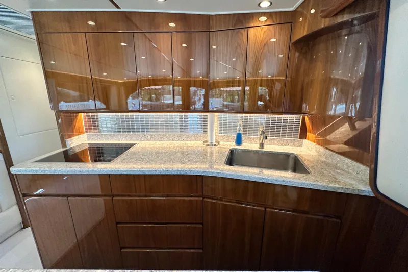 Slide: The Image of Luxurious kitchen in 2017 Viking 55 Convertible yacht with sleek wood cabinetry and modern fixtures. - 128