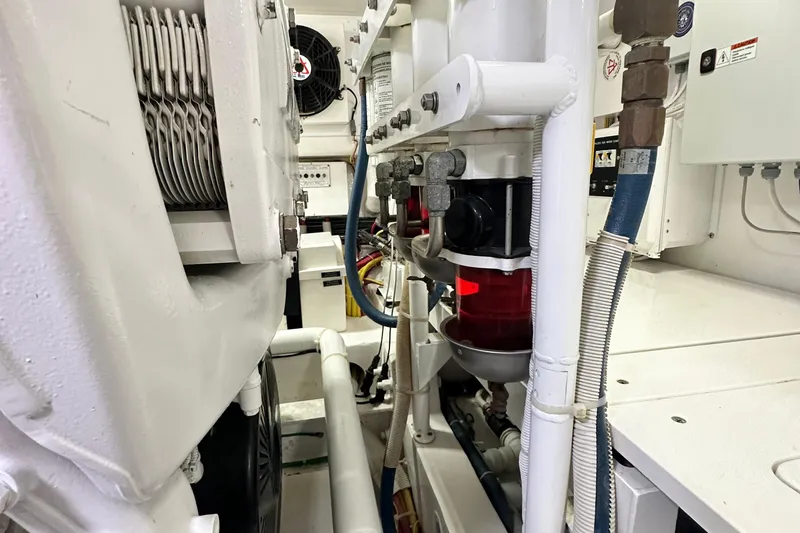 Slide: The Image of Engine room of 2017 Viking 55 Convertible yacht, showcasing mechanical components and piping. - 136
