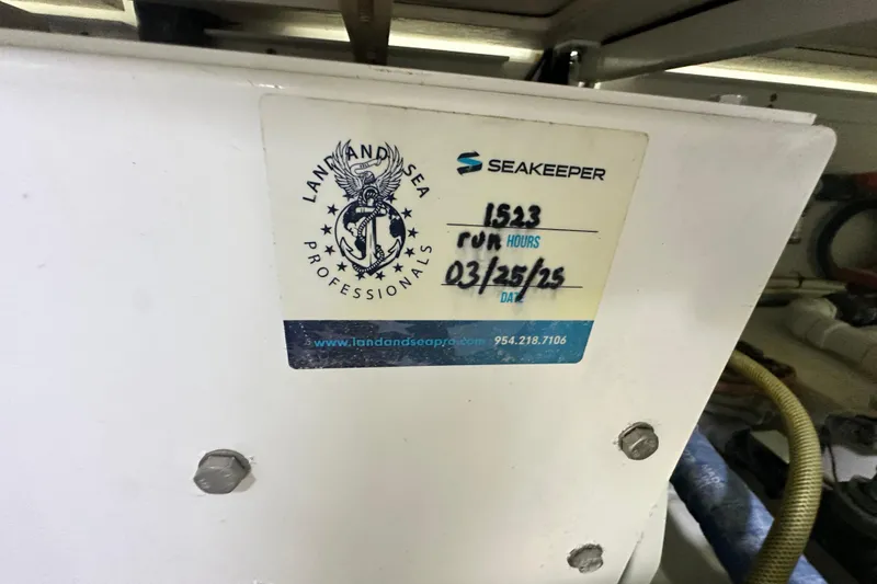 Slide: The Image of Sticker on equipment showing "Land and Sea Professionals" and "Seakeeper" with run hours and date. - 142