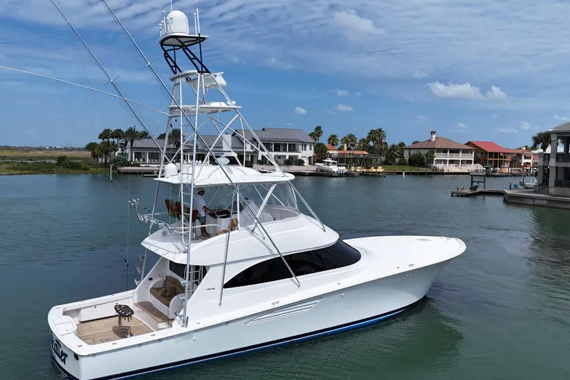 Slide: The Image of 2017 Viking 55 Convertible yacht docked in a scenic marina setting. - 19