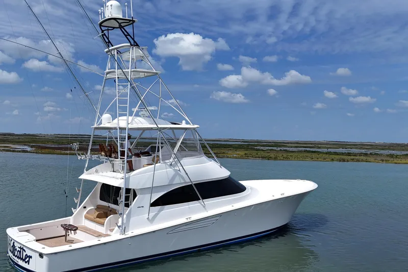 Slide: The Image of 2017 Viking 55 Convertible yacht on calm water under blue sky. - 26