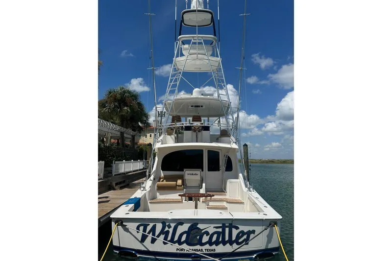 Slide: The Image of 2017 Viking 55 Convertible yacht docked, featuring "Wildcatter" name, clear sky background. - 31
