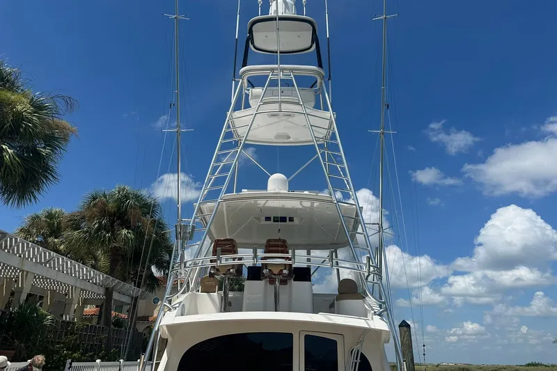 Slide: The Image of 2017 Viking 55 Convertible yacht with tower against blue sky and palm trees. - 33
