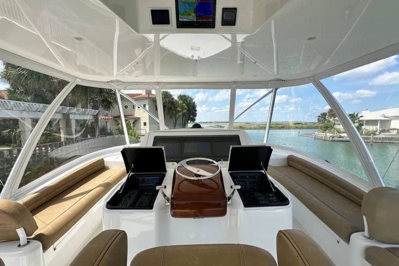 Slide: The Image of Interior view of 2017 Viking 55 Convertible yacht helm with scenic waterway backdrop. - 35