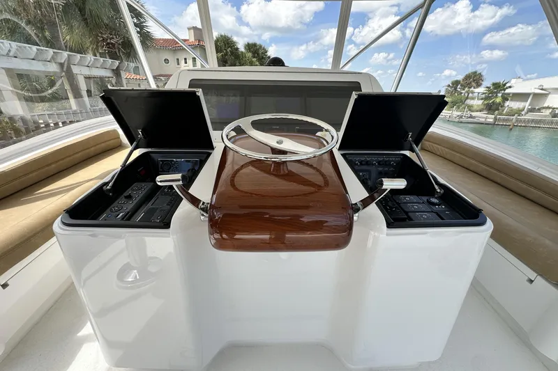 Slide: The Image of 2017 Viking 55 Convertible yacht helm with dual control panels and wooden steering wheel. - 39