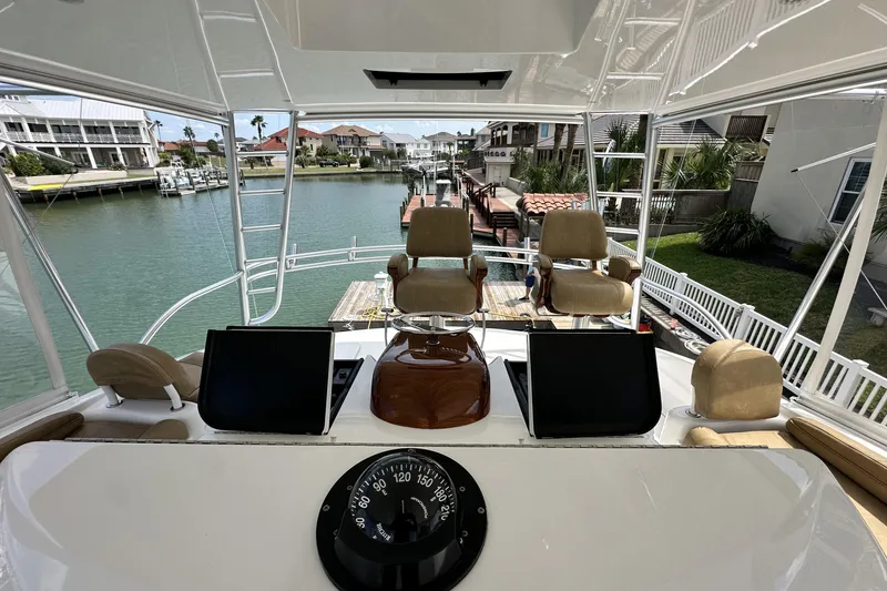 Slide: The Image of 2017 Viking 55 Convertible yacht helm with dual seats and navigation equipment. - 42