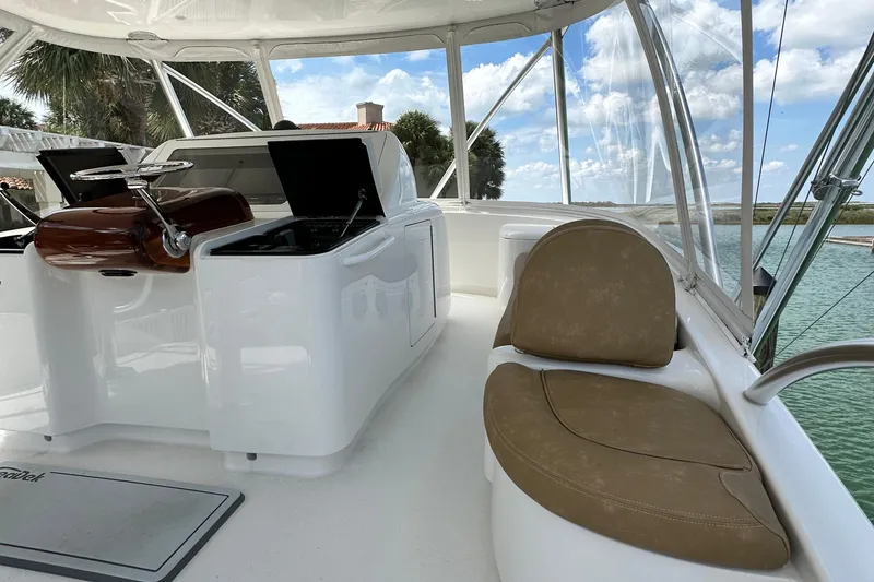 Slide: The Image of 2017 Viking 55 Convertible yacht interior with helm and seating, overlooking serene waters. - 48