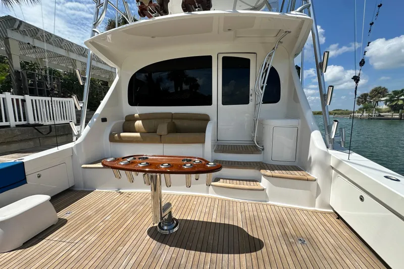 Slide: The Image of 2017 Viking 55 Convertible yacht deck with seating and fishing rod holders. - 52