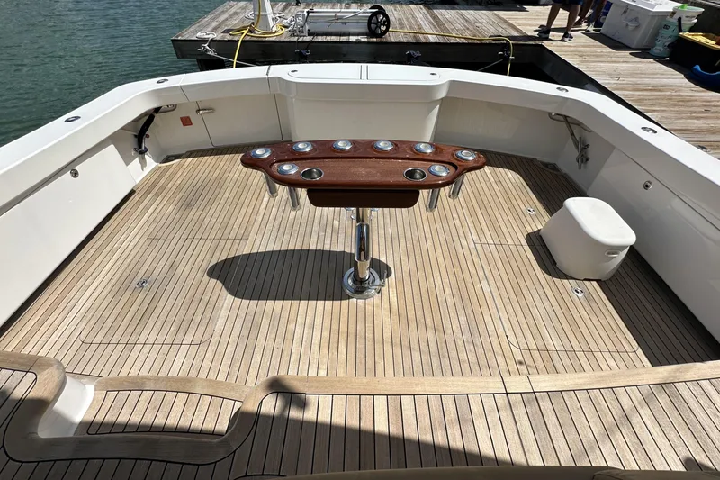 Slide: The Image of Spacious deck of 2017 Viking 55 Convertible yacht with wooden flooring and central table. - 54