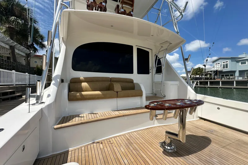 Slide: The Image of 2017 Viking 55 Convertible yacht with teak deck, cushioned seating, and fishing rod holders. - 58