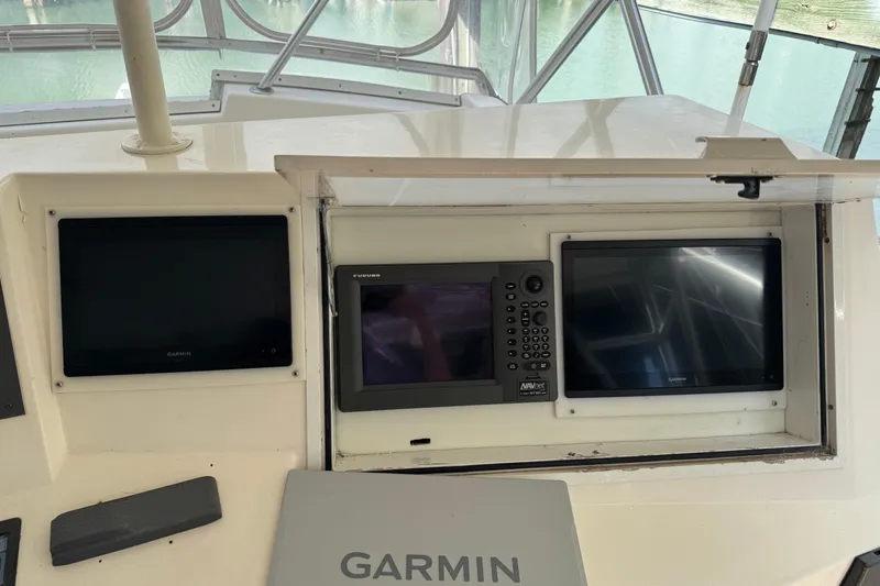 Slide: The Image of 1993 Viking 50 Convertible boat dashboard with Garmin and Furuno navigation displays. - 10