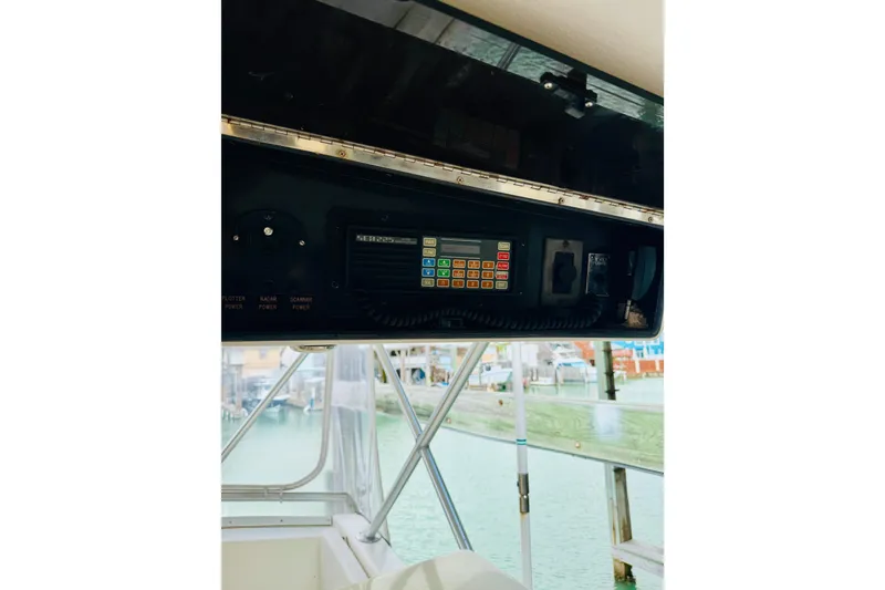 Slide: The Image of 1993 Viking 50 Convertible boat dashboard with electronic controls and marina view. - 13