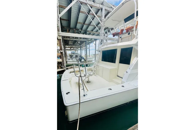 Slide: The Image of 1993 Viking 50 Convertible yacht docked under a metal canopy. - 3