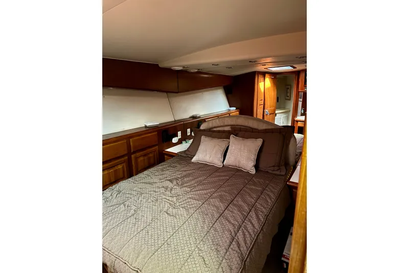 Slide: The Image of Cozy bedroom interior of 1993 Viking 50 Convertible yacht with wooden cabinetry. - 30