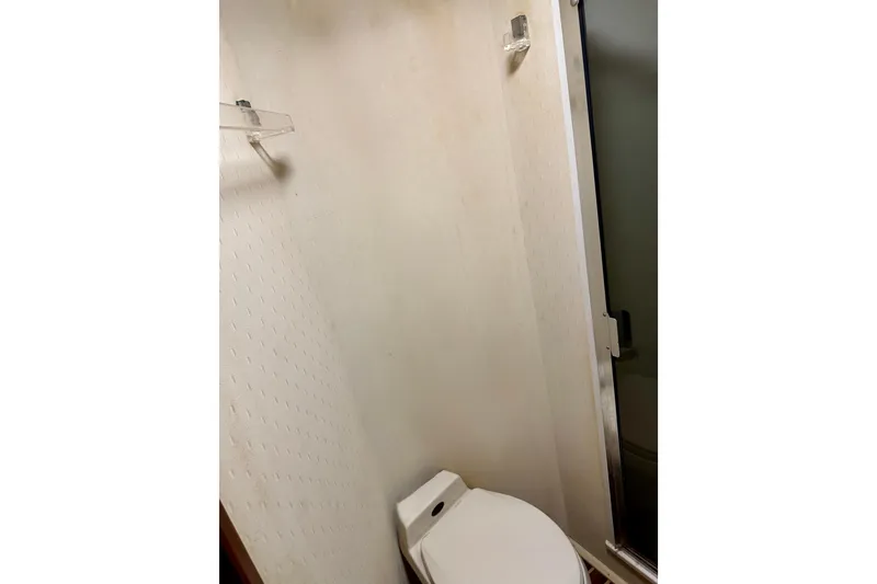 Slide: The Image of Bathroom interior of 1993 Viking 50 Convertible yacht, featuring toilet and shower. - 36