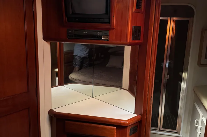 Slide: The Image of 1993 Viking 50 Convertible yacht interior with TV, mirrors, and wood cabinetry. - 38
