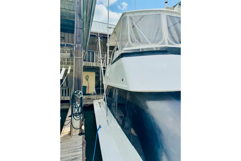 Slide: The Image of 1993 Viking 50 Convertible yacht docked at marina, side view. - 5