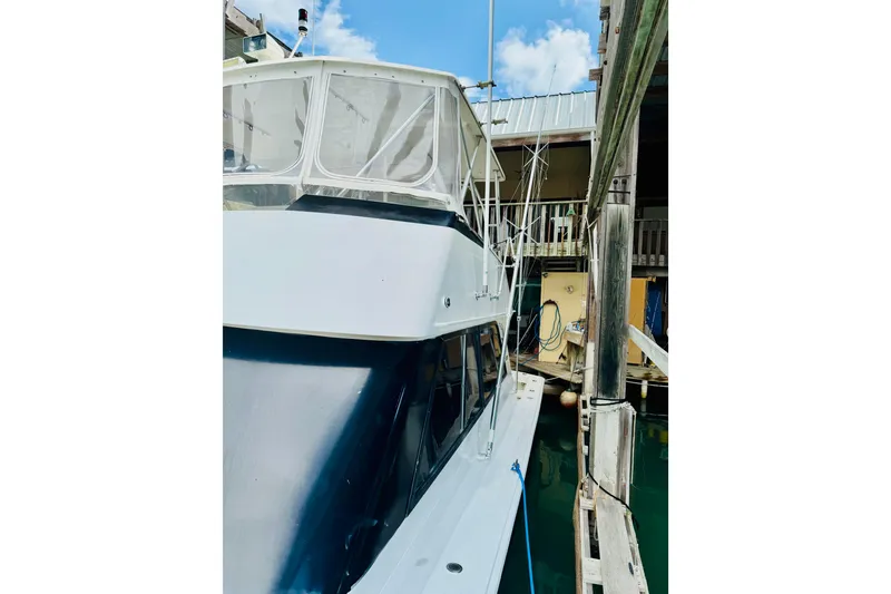 Slide: The Image of 1993 Viking 50 Convertible yacht docked in a marina, showcasing sleek design. - 6