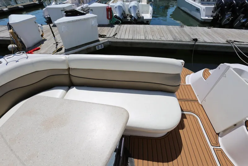 Slide: The Image of 2005 Four Winns 348 Vista boat interior with cushioned seating and table at dock. - 23