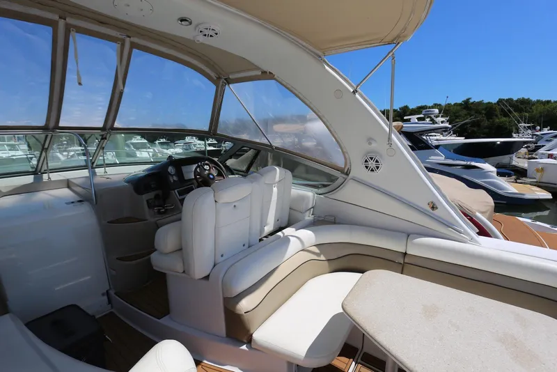 Slide: The Image of 2005 Four Winns 348 Vista yacht interior with white seating and helm, docked at marina. - 25