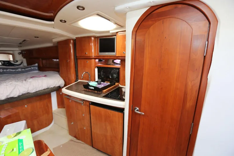 Slide: The Image of Interior of 2005 Four Winns 348 Vista boat with wood cabinetry and cozy sleeping area. - 42