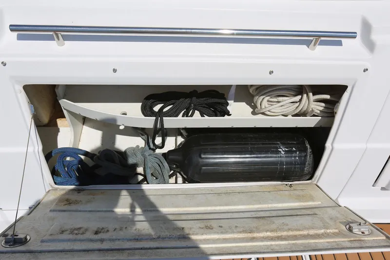 Slide: The Image of Storage compartment on a 2005 Four Winns 348 Vista boat with ropes and fender. - 53