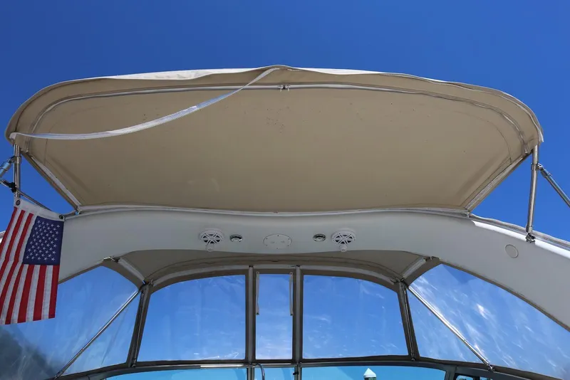 Slide: The Image of 2005 Four Winns 348 Vista boat canopy with American flag against clear blue sky. - 8