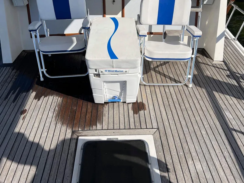 Slide: The Image of Deck of 1983 Lindmark 39 Trawler with chairs and cooler on wooden flooring. - 26