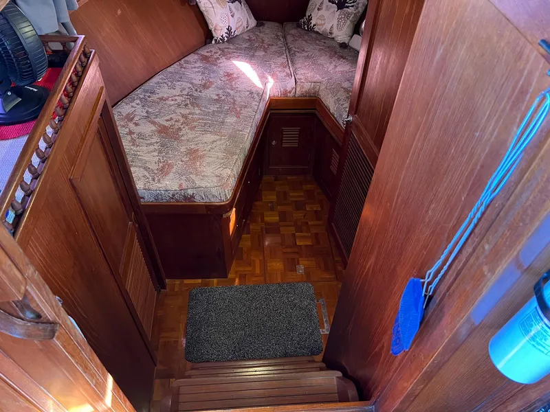 Slide: The Image of Cozy cabin interior of 1983 Lindmark 39 Trawler with wooden finish and cushioned seating. - 43