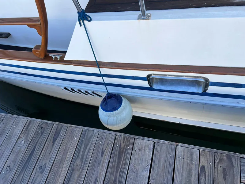 Slide: The Image of 1983 Lindmark 39 Trawler docked with fender, wooden deck visible. - 8