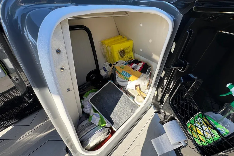 Slide: The Image of Storage compartment of 2021 Yamaha Boats 255XD, containing various boating accessories and supplies. - 29