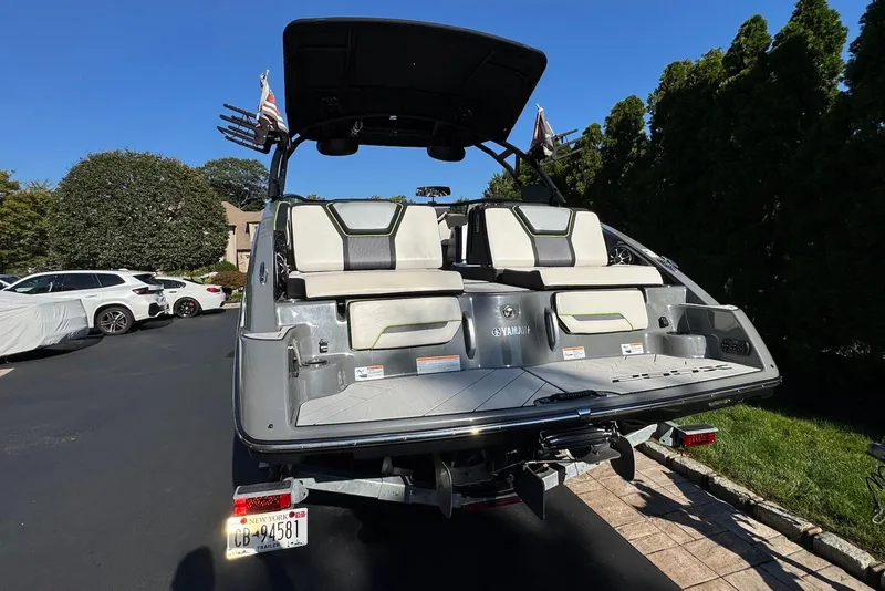 Slide: The Image of 2021 Yamaha Boats 255XD in driveway, showcasing rear seating and sleek design. - 6