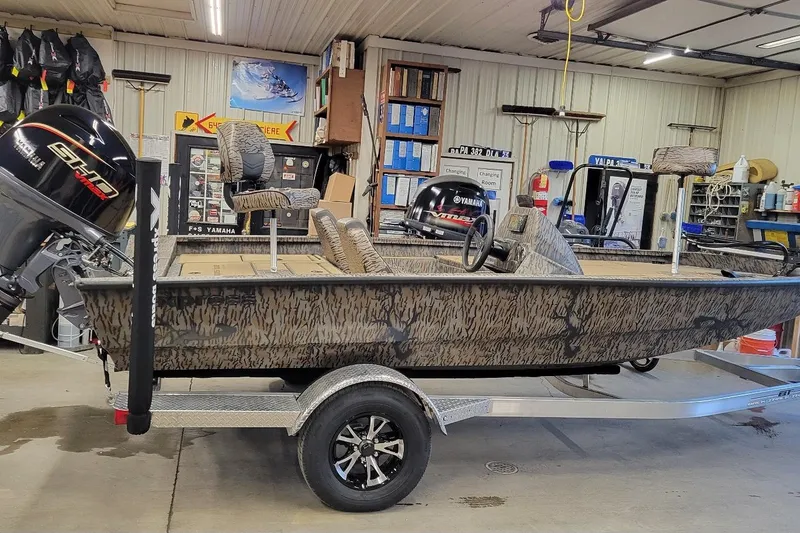 The Image of 2026 Xpress H18 Bass boat in a garage, featuring Yamaha outboard motor. - 1