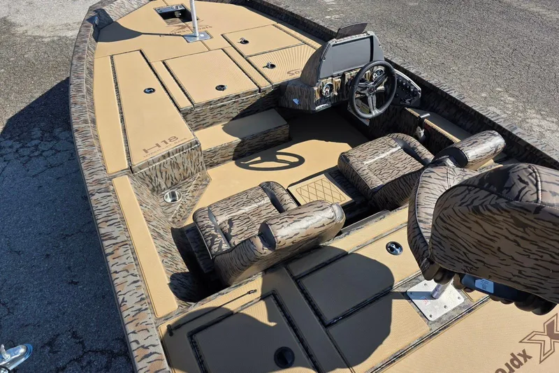 Slide: The Image of 2026 Xpress H18 Bass boat interior with camouflage seating and modern dashboard. - 13