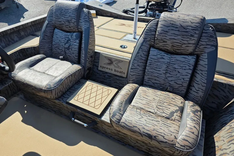 Slide: The Image of 2026 Xpress H18 Bass boat interior with camo-patterned seats and logo. - 19