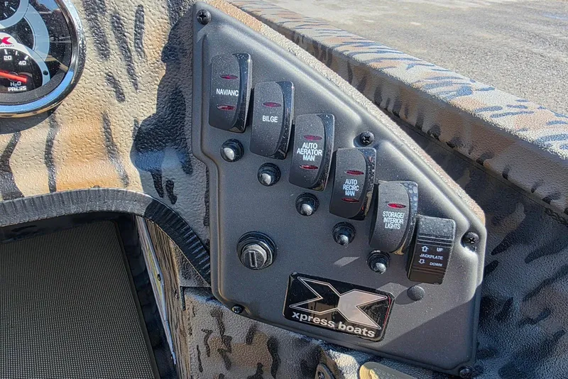 Slide: The Image of Control panel of 2026 Xpress H18 Bass boat with various switches and gauges. - 20