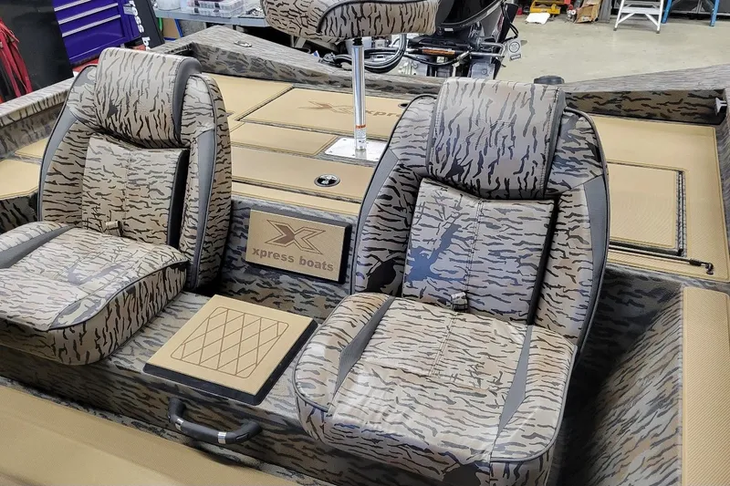 Slide: The Image of 2026 Xpress H18 Bass boat interior with camo-patterned seats and branding. - 4