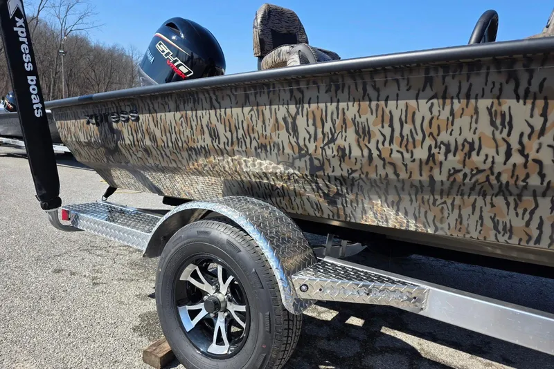 Slide: The Image of 2026 Xpress H18 Bass boat with camouflage design on a trailer. - 9