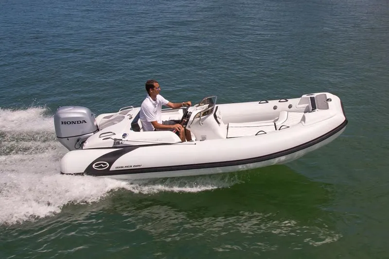 Slide: The Image of Manufacturer Provided Image: 2024 Walker Bay Generation 525 DLX boat cruising on water. - 1