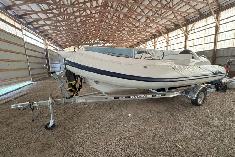 Slide: The Image of 2024 Walker Bay Generation 525 boat on trailer in a spacious indoor storage facility. - 13